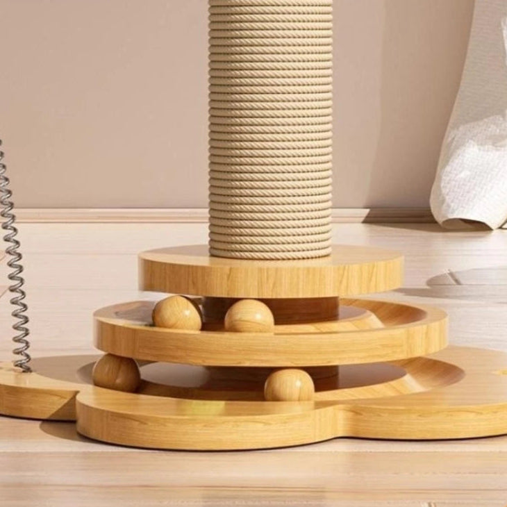 Wooden cat toy with multiple levels and a cylindrical rope perch on a light wooden floor.