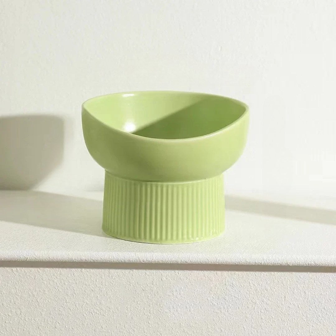 Green ceramic bowl on a white surface with a light background