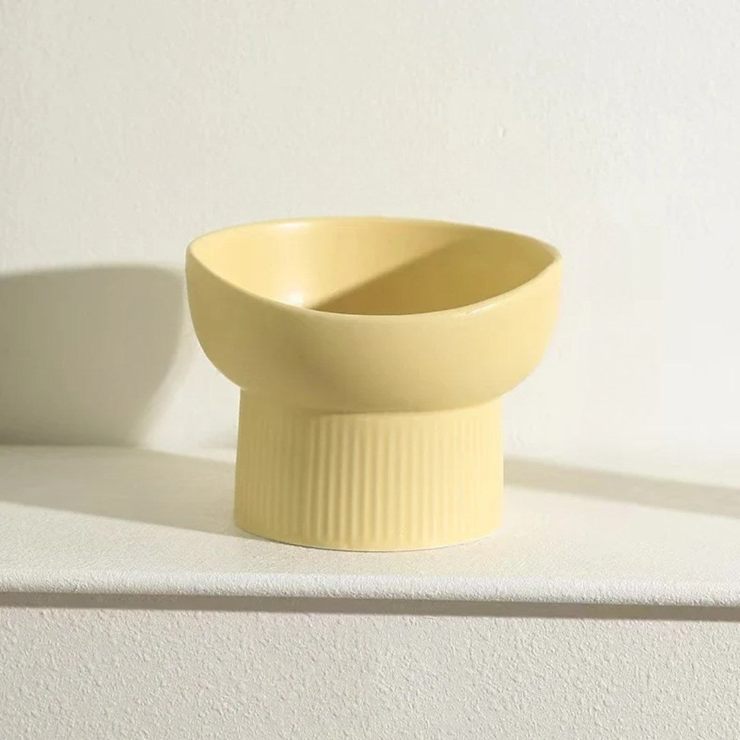 Yellow ceramic bowl on a light surface with a white background