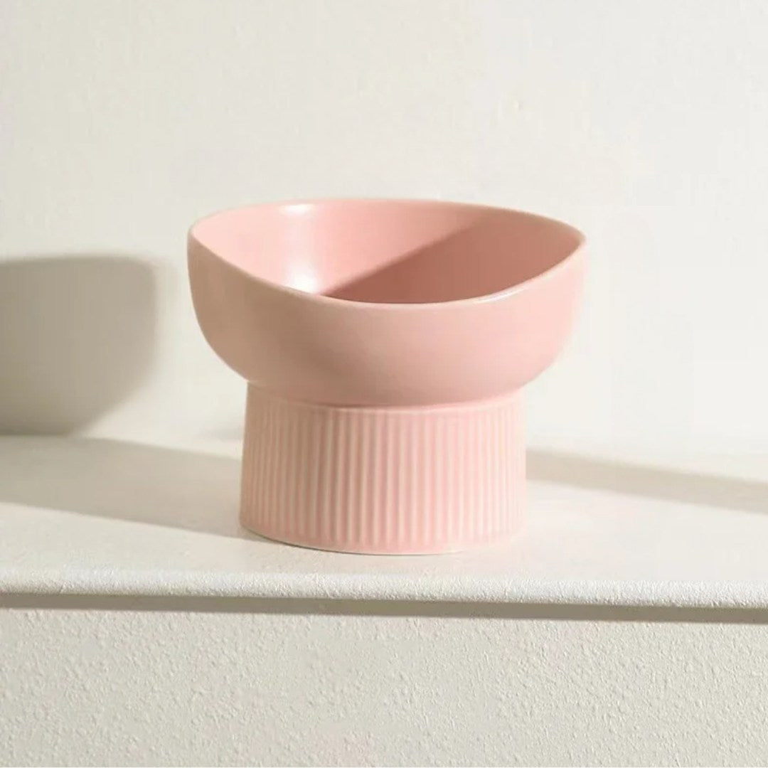 Pink ceramic bowl on a white surface with a light background