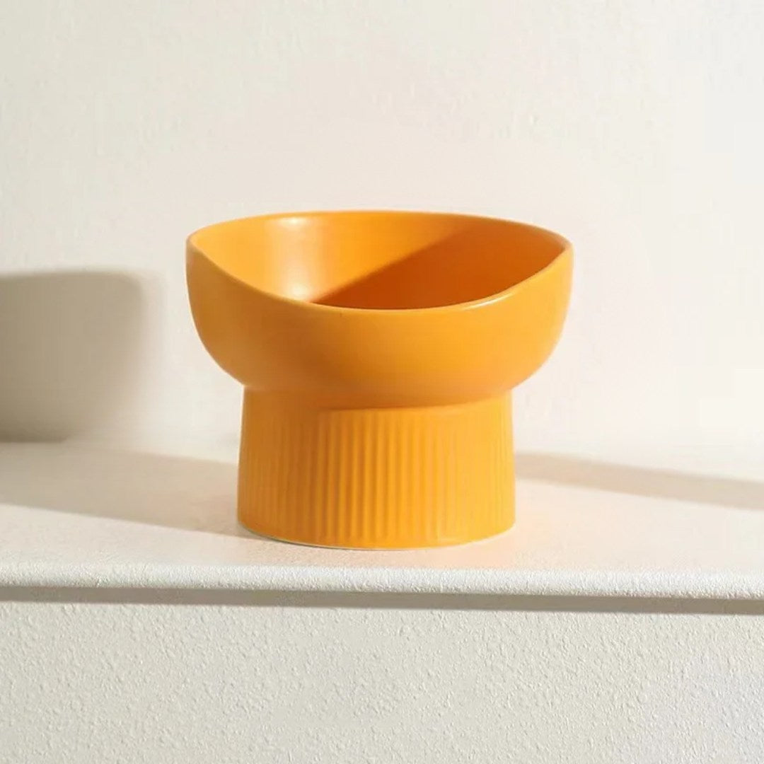 Orange ceramic bowl on a white surface with a light background