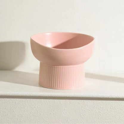Pink ceramic bowl on a white surface with a light background