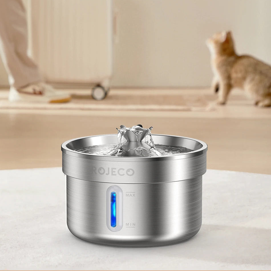 Stainless steel pet water fountain with text about capacity and usage, blurred background with a cat.